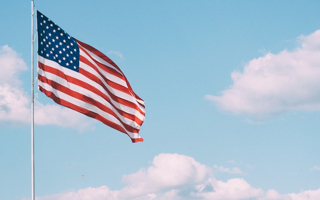 flag of U.S.A. under white clouds during daytime