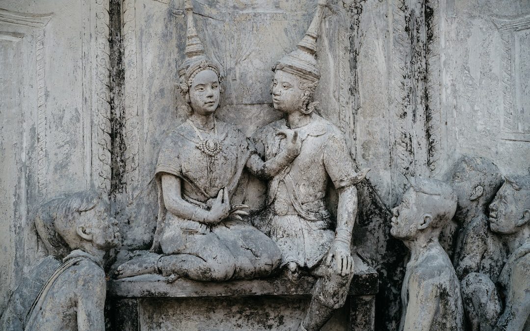 a group of statues of people sitting on a bench