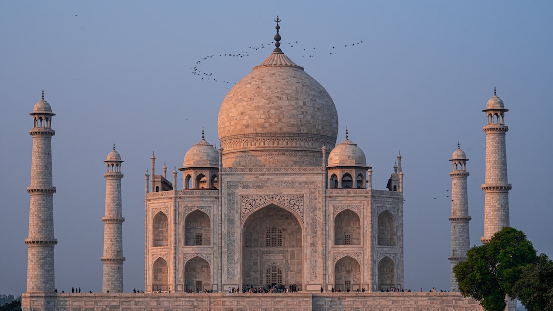 a large building with towers with Taj Mahal in the background