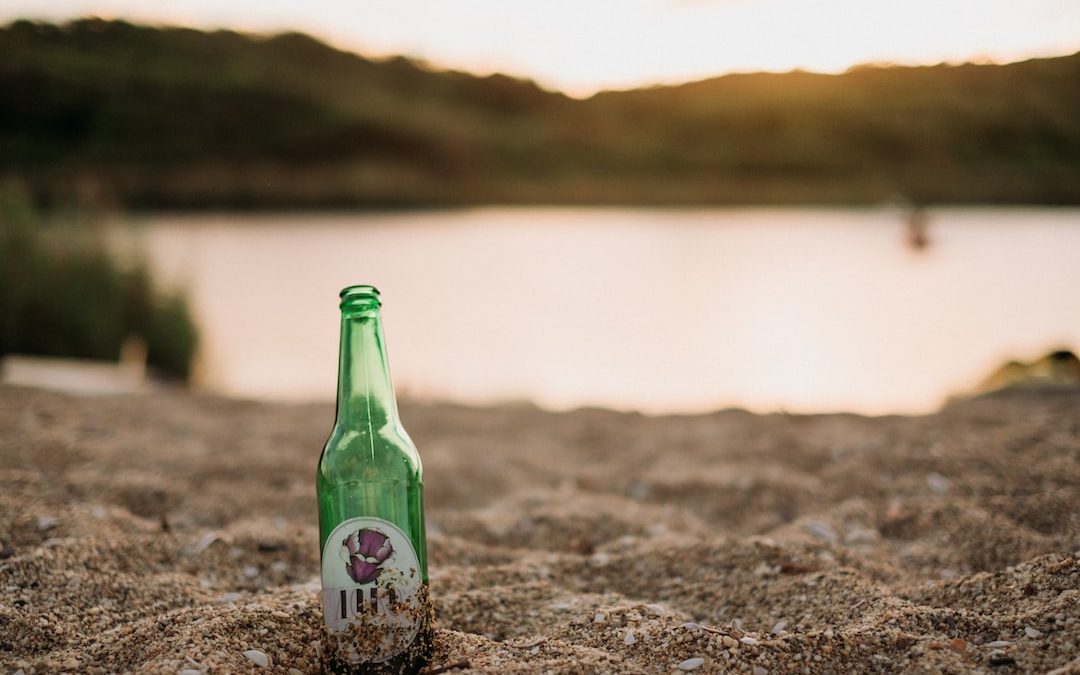 a bottle of beer on a beach