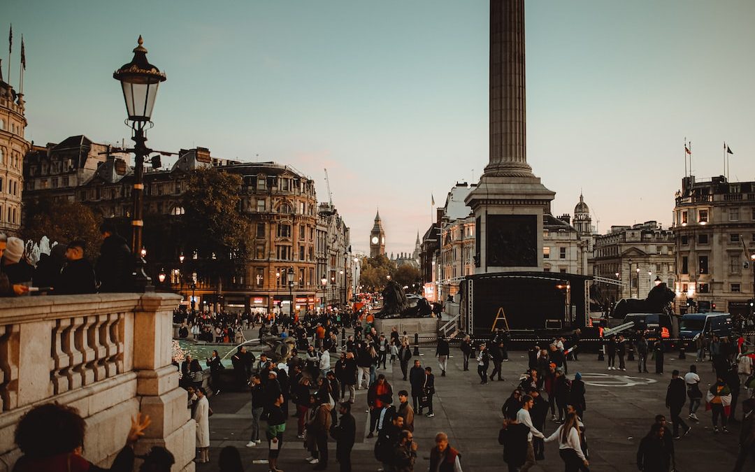 a crowd of people walking around a city square