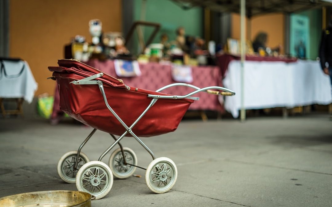 selective focus photography of red bassinet stroller