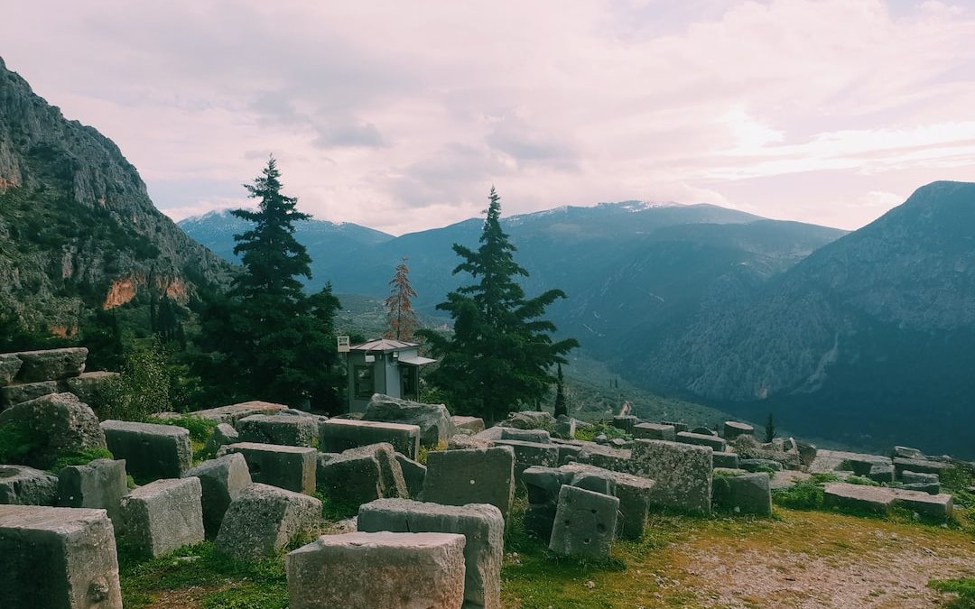 a group of large rocks sitting on top of a lush green hillside