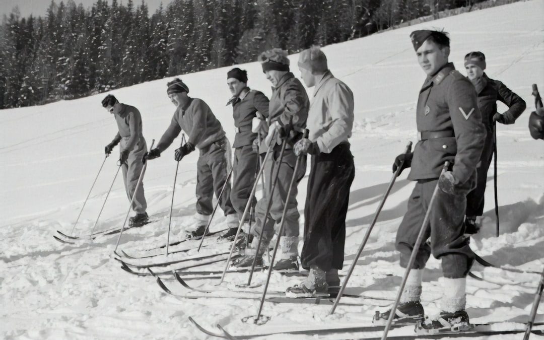 grayscale photography of people doing snow skies during daytime