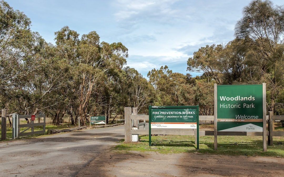 a sign for woodlandss historic park on a dirt road