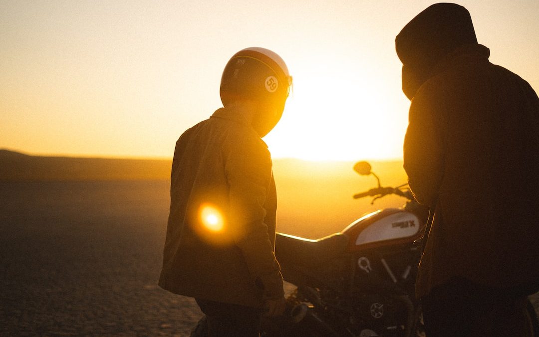 silhouette of man and woman riding motorcycle during sunset