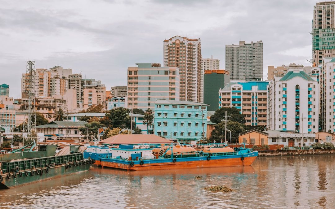 blue and brown boat on water near city buildings during daytime