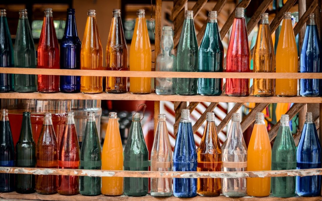 a shelf filled with lots of different colored bottles