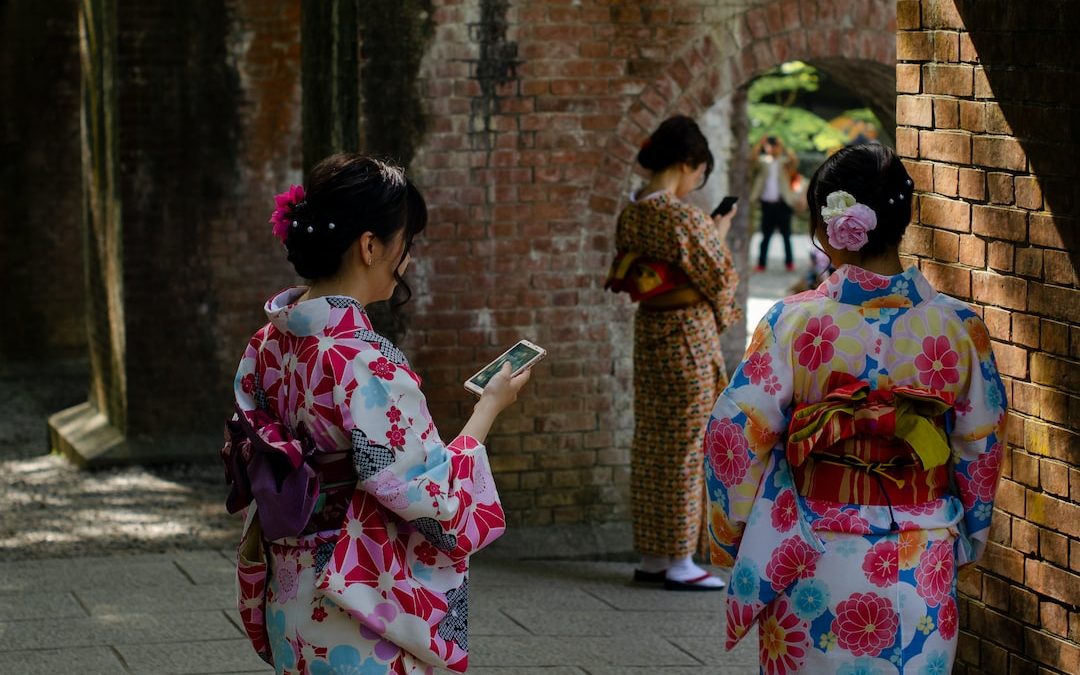 three women wearing kimono dresses during daytime