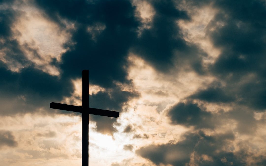 silhouette of cross under cloudy sky