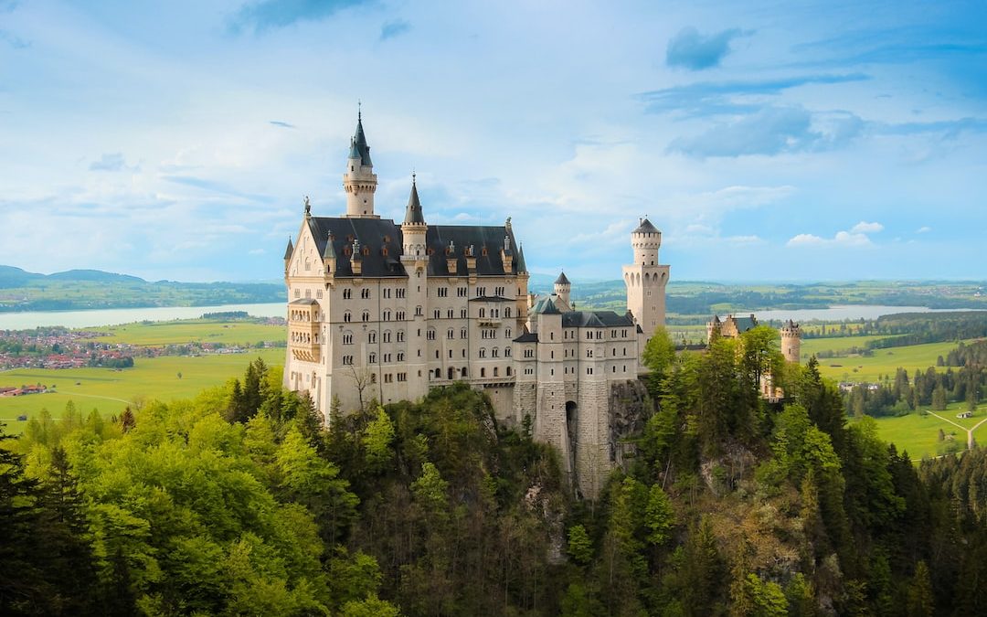 white and gray castle on top of hill