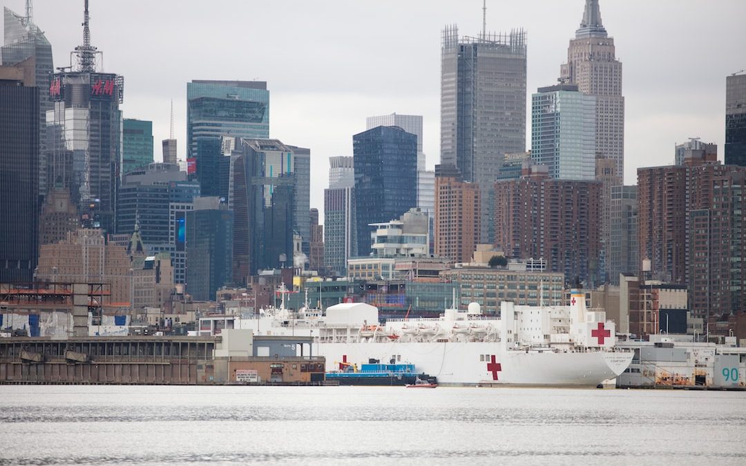 white ship on body of water near city buildings during daytime