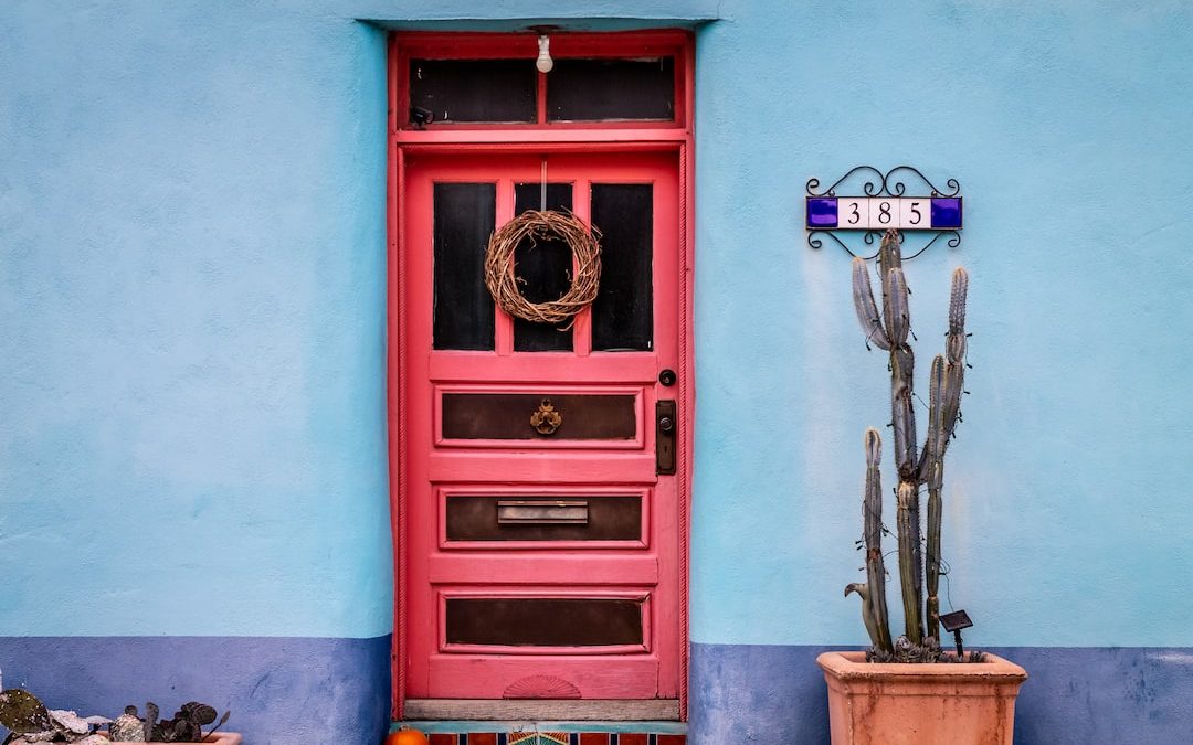 red wooden door with brass door knob