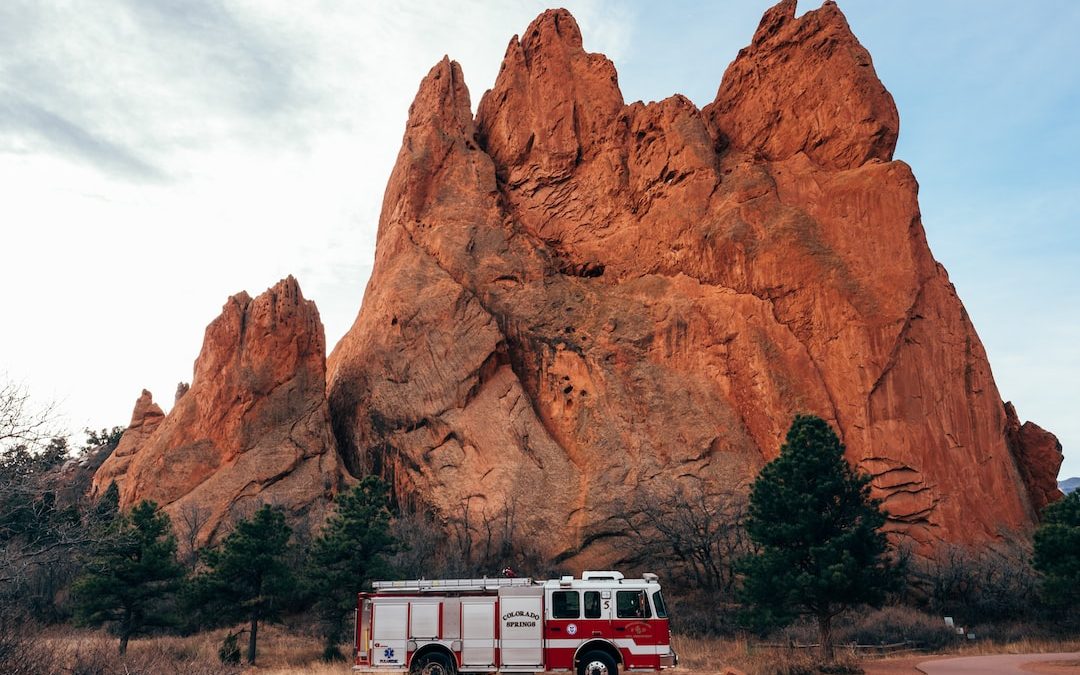 white and red firetruck near brown rock formation