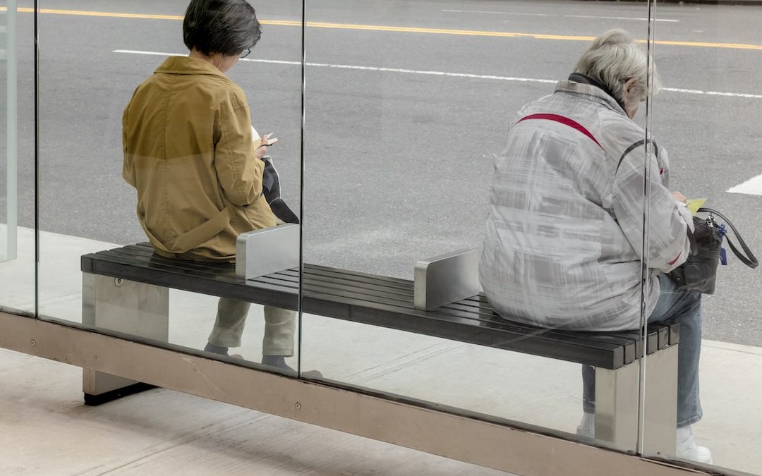 woman in gray jacket standing beside glass window