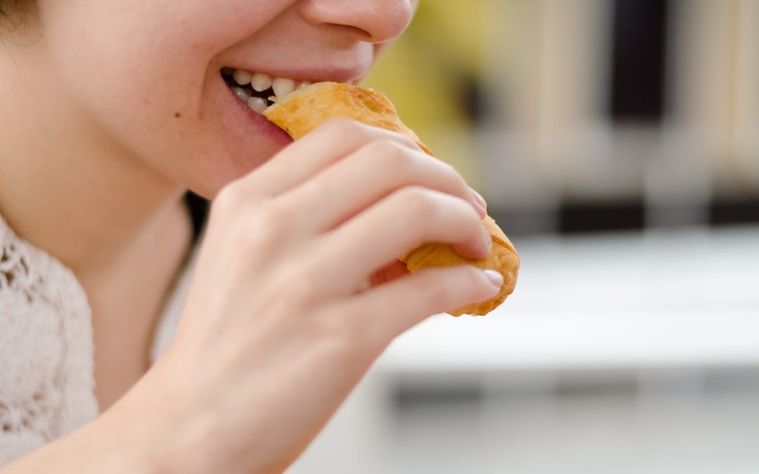 woman eating bread during daytime