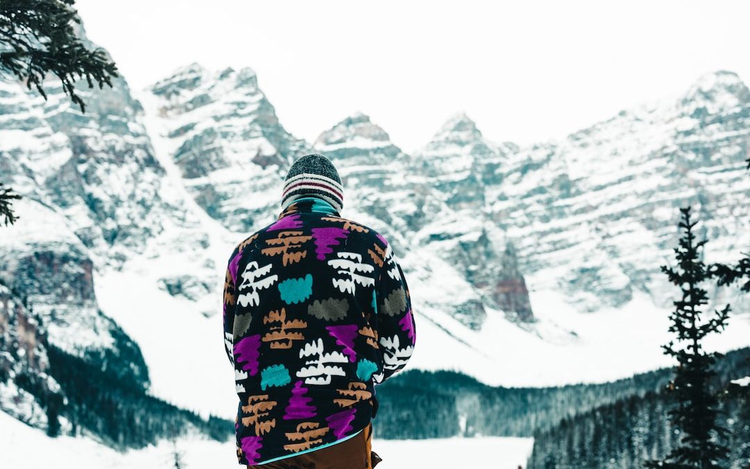 a man standing on top of a snow covered slope