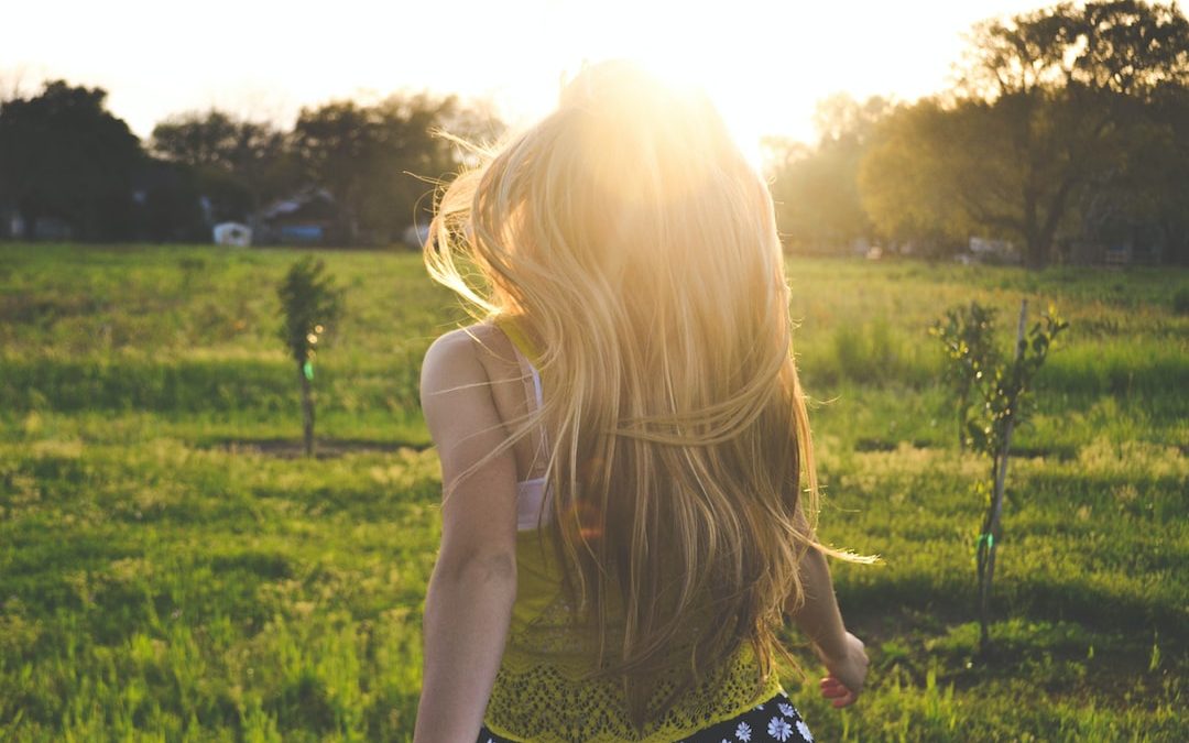 woman walking on lawn with trees