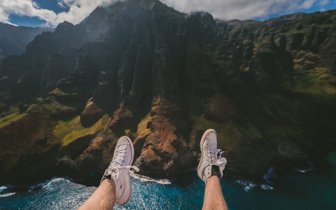 person above mountain and body of water