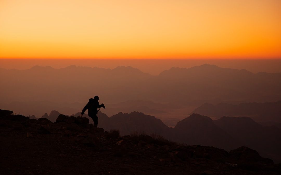 a person standing on top of a mountain at sunset