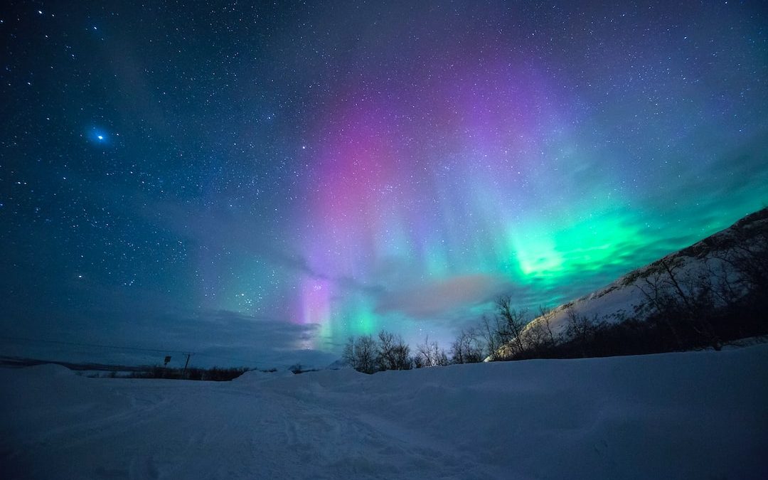 northern lights over snow-capped mountian