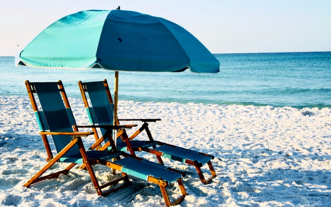 two brown wooden folding chairs on beach during daytime