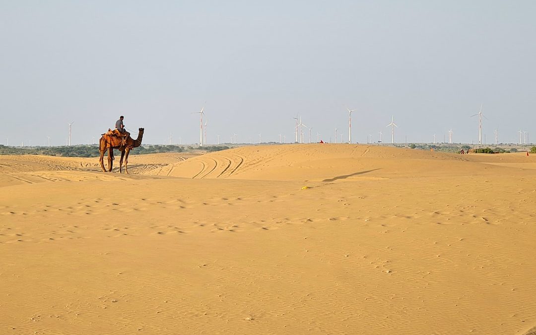 a man riding a camel in the desert