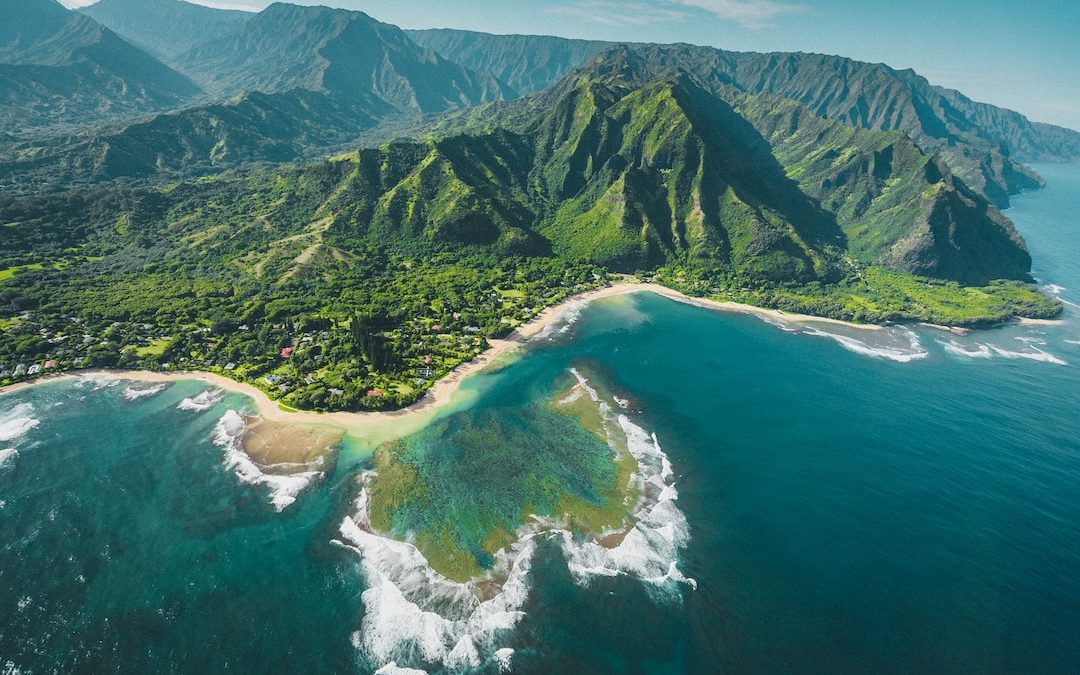 aerial view of green and brown mountains and lake