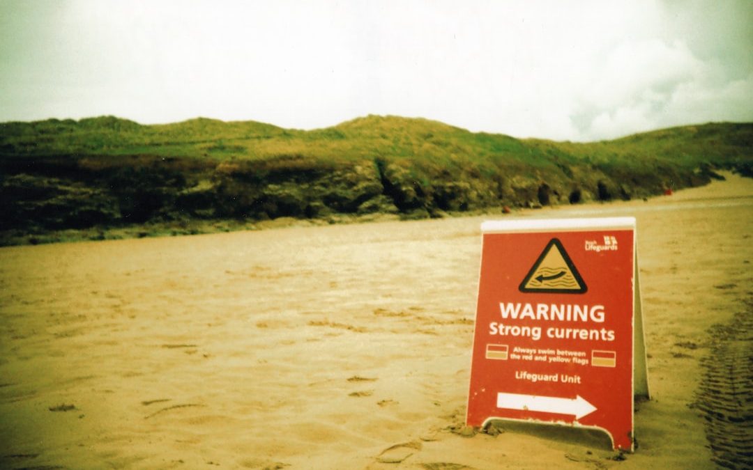 brown and white signage on brown sand during daytime