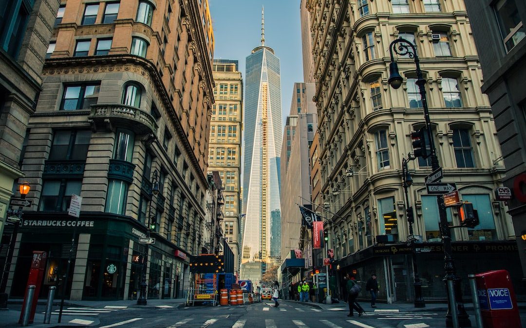 down view of white and blue glass tower in between buildings during daytime