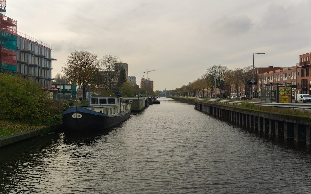 two boats are docked on the side of a river