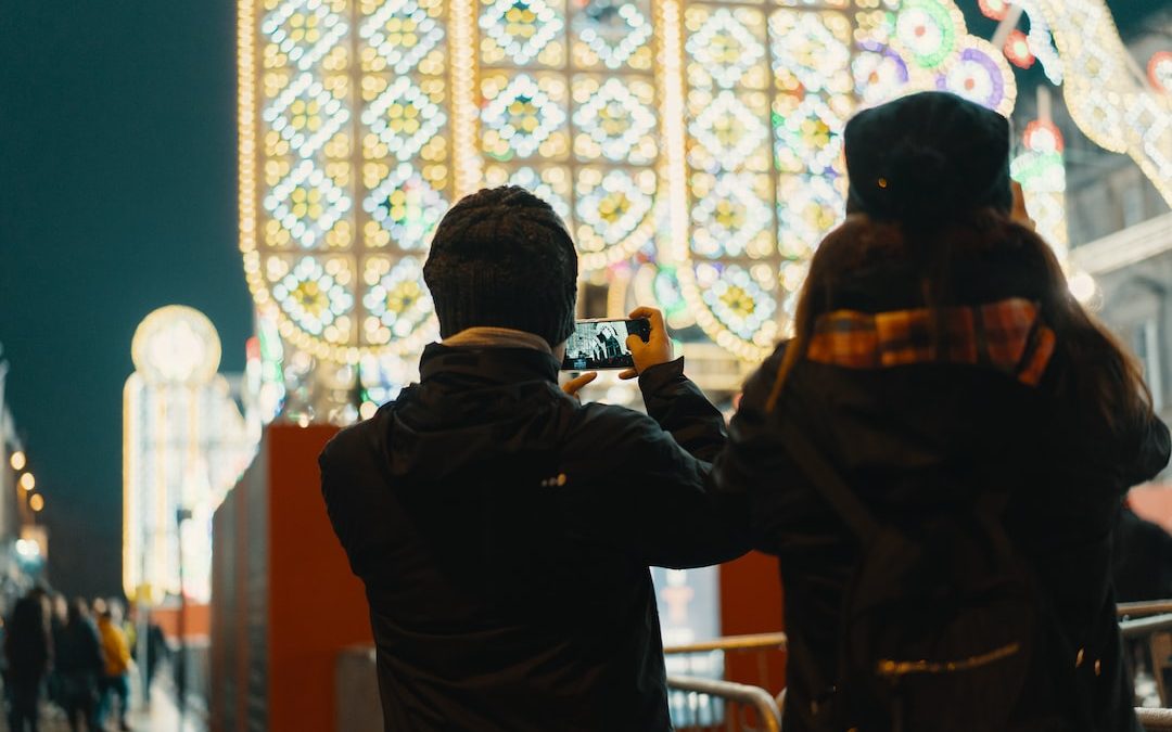 man standing holding phone on selective focus photography