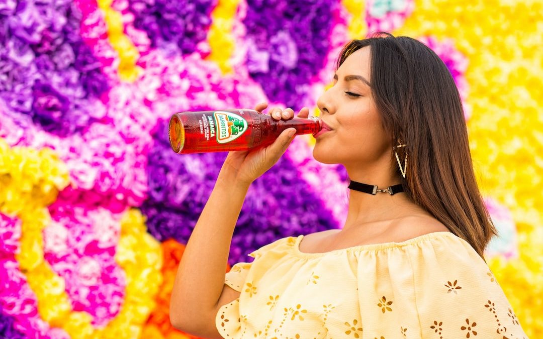woman in white floral dress drinking coca cola