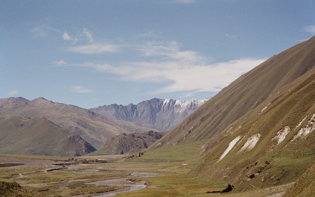 a view of a valley with mountains in the background