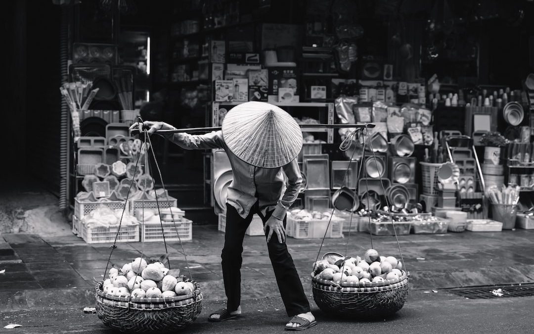 a person with an umbrella and two baskets of eggs