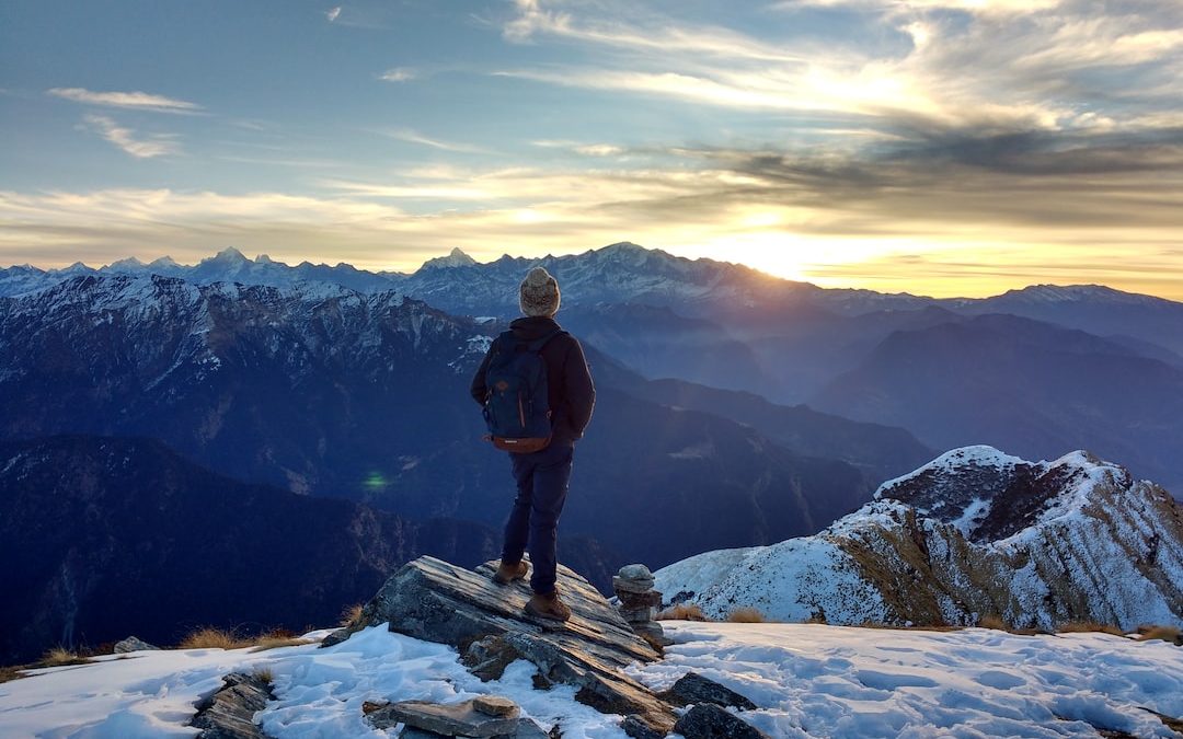 person standing on top of the mountain facing sunrise