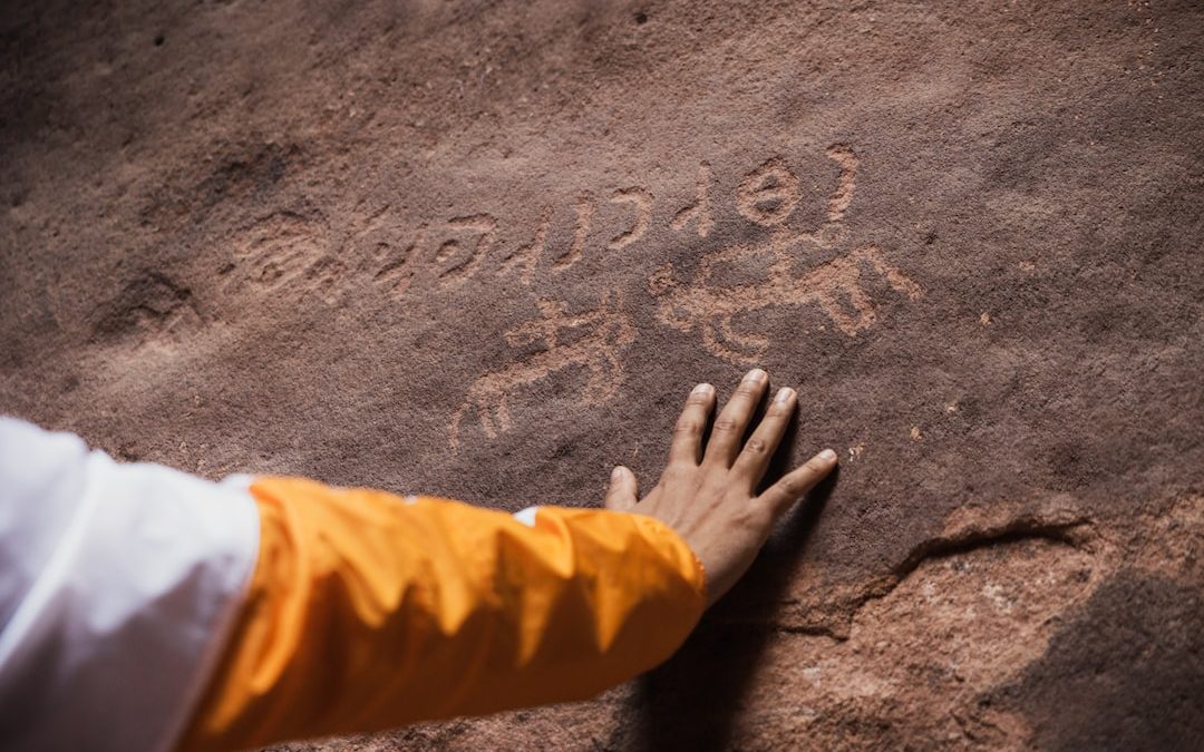 a person with their hand on a rock