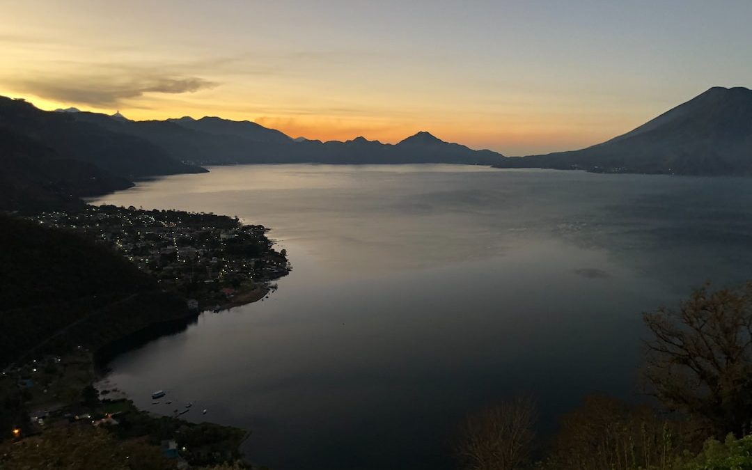 body of water between mountain at golden hour