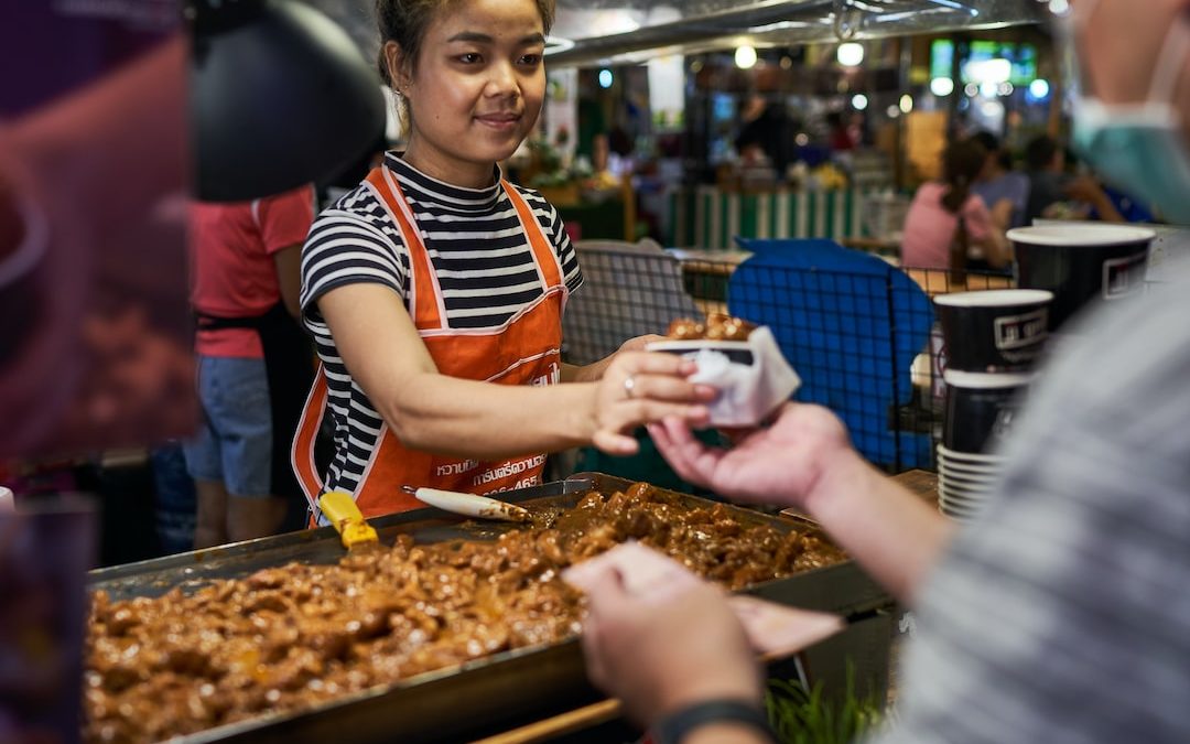 a woman in an apron is serving food to another woman