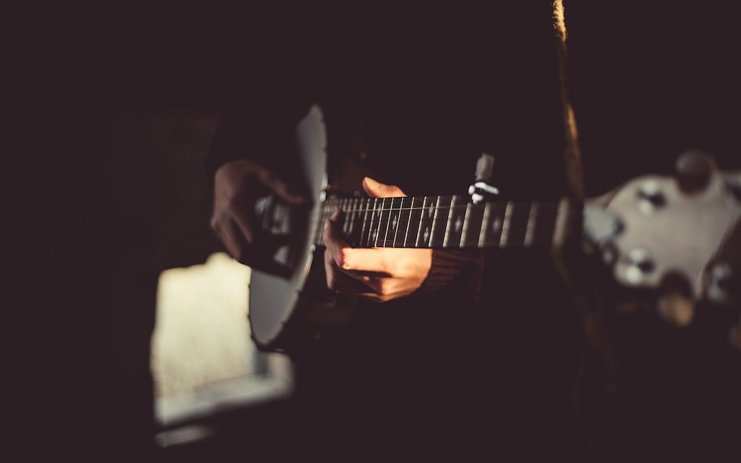 person playing banjo inside dark room