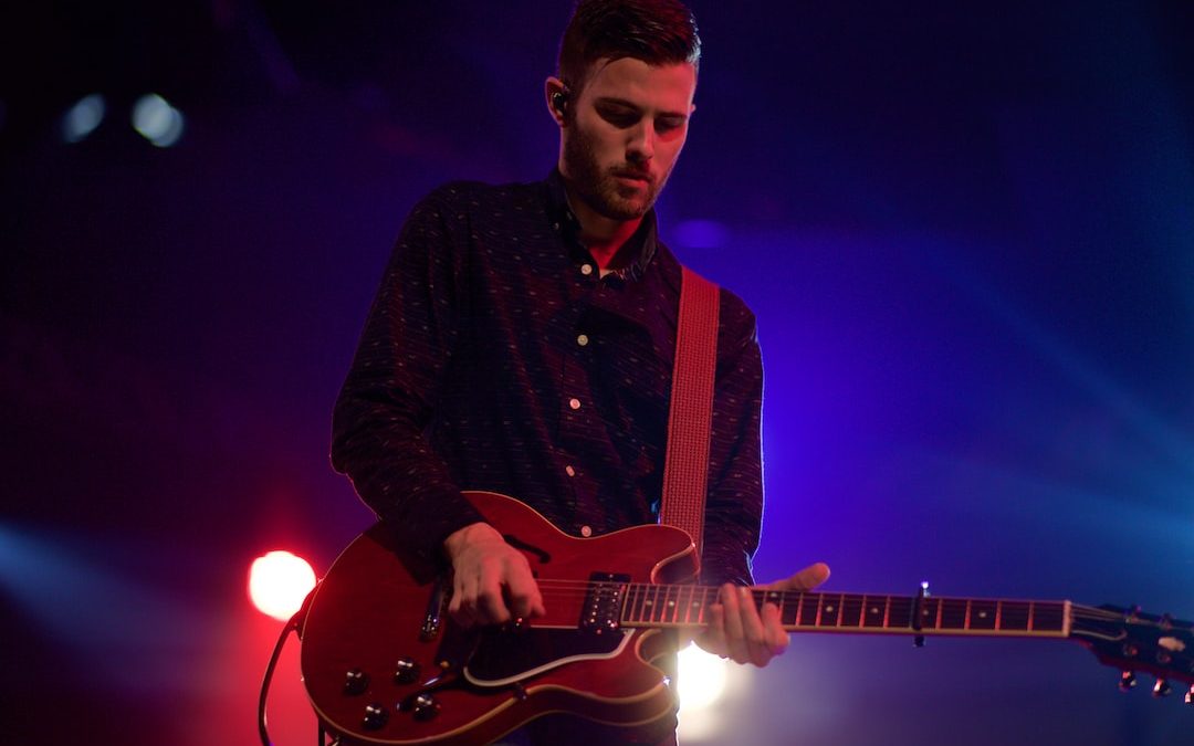 man playing black electric guitar