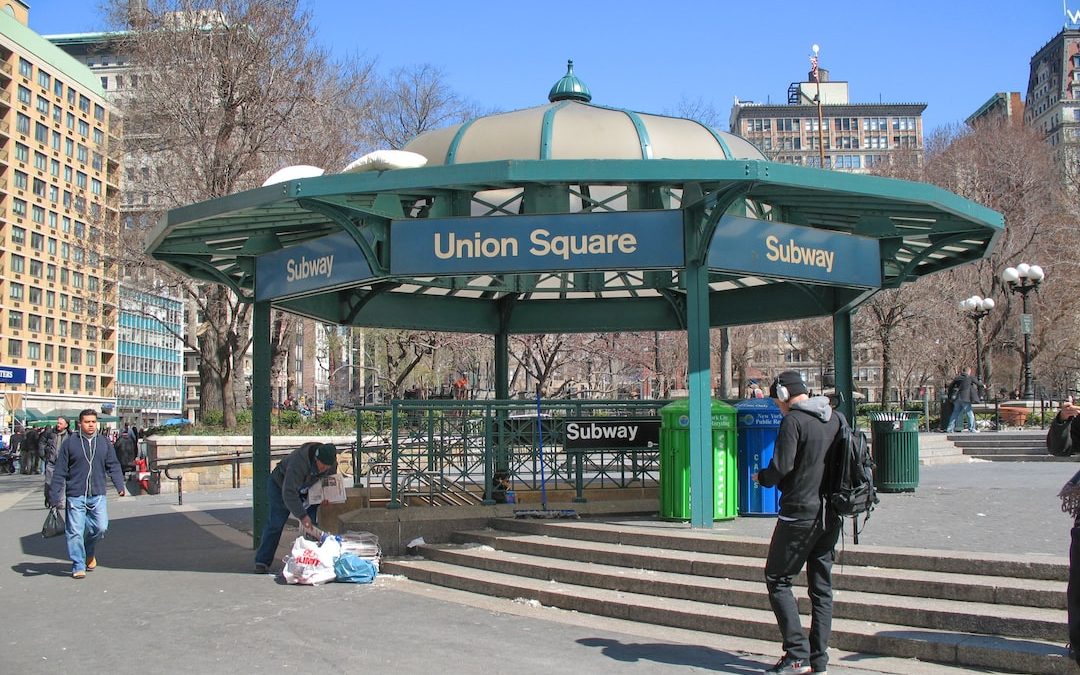 a group of people standing around a green and white gazebo