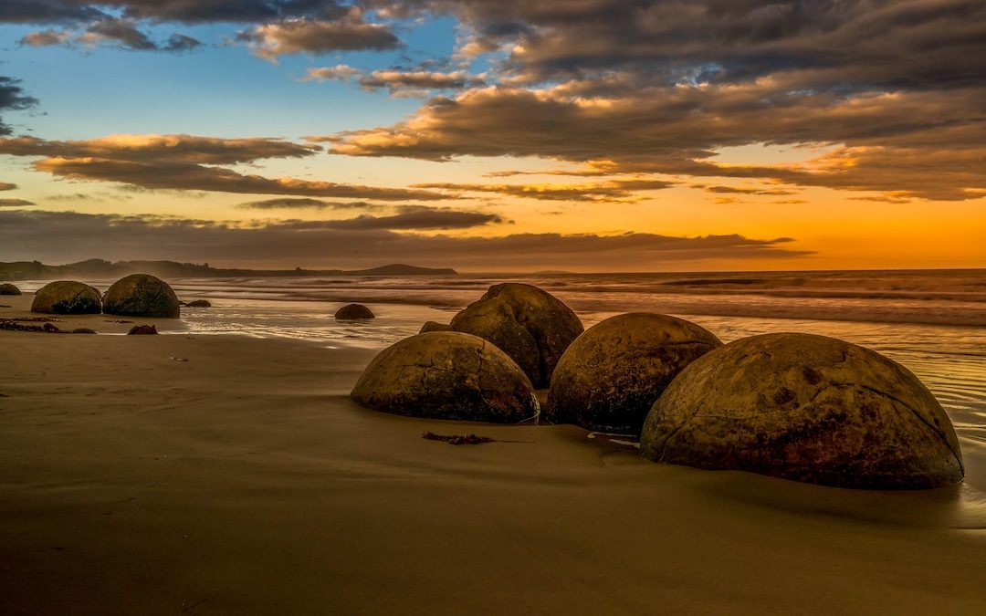 brown rocks on beach during sunset