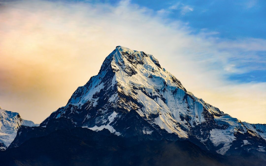 snow covered mountain under cloudy sky during daytime