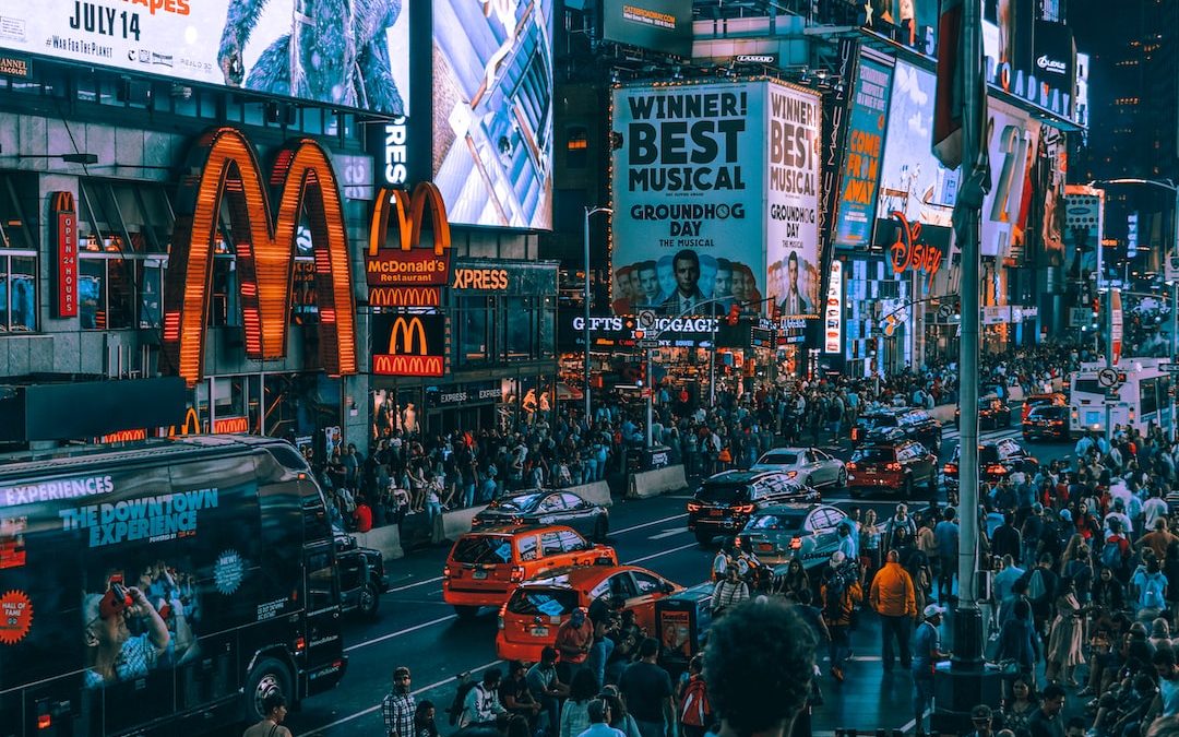 crowd of people waking on street in front of McDonald's building