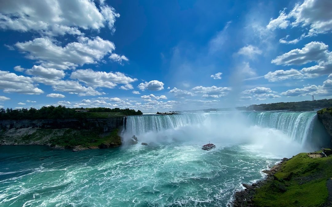 waterfalls under blue sky and white clouds during daytime