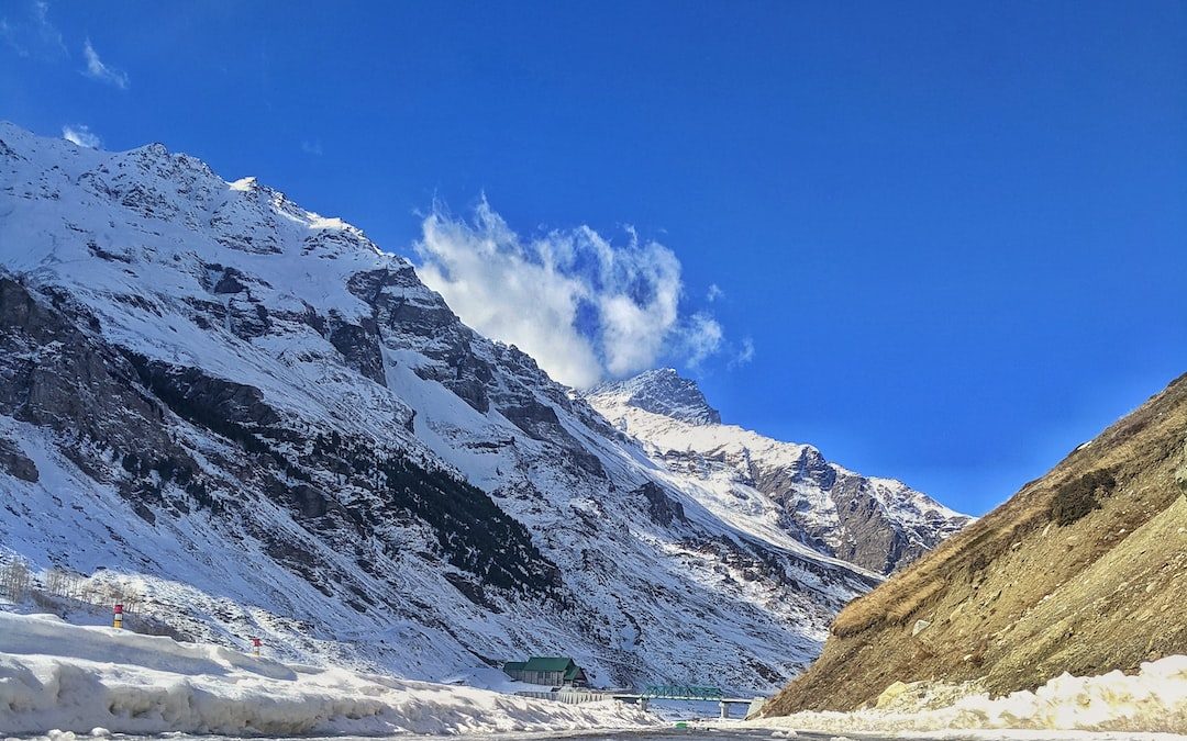 a snowy mountain with a road going through it