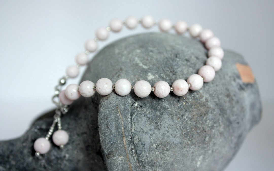 a white beaded necklace on a rock