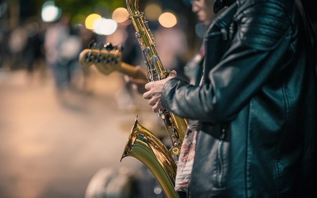 a man playing a saxophone on a city street