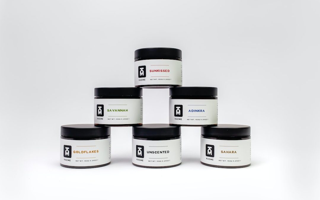 a group of five jars of body butter on a white background